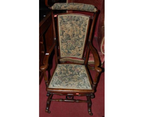 An Edwardian mahogany and floral tapestry upholstered rocking elbow chair