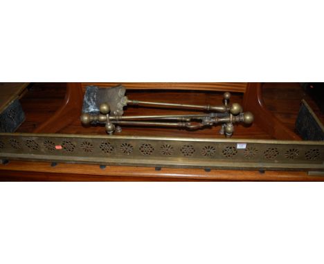 An Edwardian pierced brass fire fender, together with pair of brass andirons and three various fire tools (6)