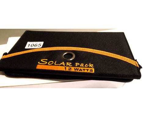 New old stock 12 watt folding solar panel pack with two USB charging outputs. Integral part of case with magnetic catch and z