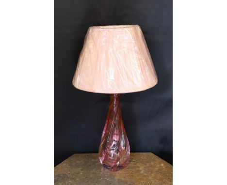 A 1960s Val Saint Lambert cranberry tinted glass table lamp, of twisted form, with replacement pleated silk shade, height 36c