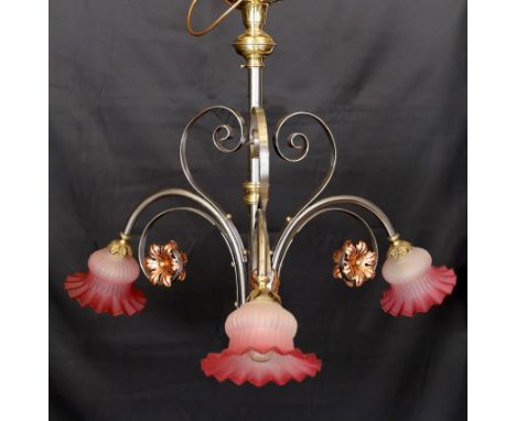 An English Arts &amp; Crafts wrought iron brass and copper three light electrolier with pink tinted opaque glass shades, heig