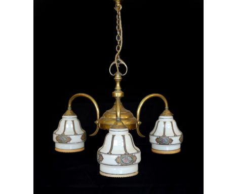 An early 20th century English lacquered brass light fitting with three stencilled opaque glass shades, height 65cm. width 50c