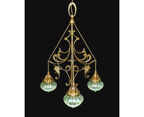 An English Arts &amp; Crafts brass light fitting with scrolling foliate branches and tinted iridescent glass shades, height 6