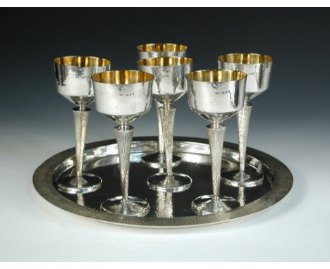 A set of six silver goblets and tray by Robert J. Turner, London 1976, each with repoussé bowl above textured stem and spread