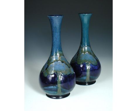 A composed pair of Moorcroft Moonlit Blue pattern bottle vases, each with slender neck to a bulbous body, painted and impress