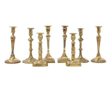Four pairs of English brass candlesticks mid 18th c early 19th c, including a pair with tapered and fluted stem on seamed rou