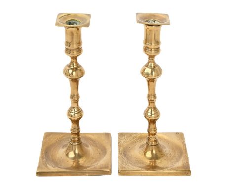 A pair of English brass candlesticks, 18th c, with cylindrical sconce, shouldered knop and dished square foot, 22cm h  Minor 