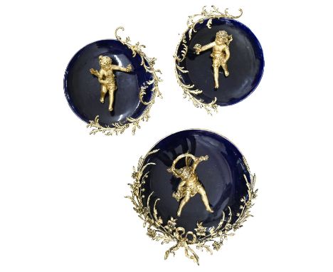 A set of three giltmetal mounted porcelain wall plaques, 19th c, applied with cherubs and bouquet decoration, 39cm w and smal