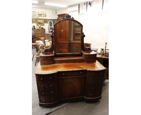 A Victorian mahogany dressing chest, arched mirror back, fitted with five trinket  drawers, the base with a central cupboard 