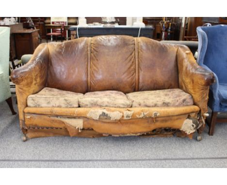 An old brown leather sofa, shaped back, tapering mahogany legs, (distressed), width 187cm