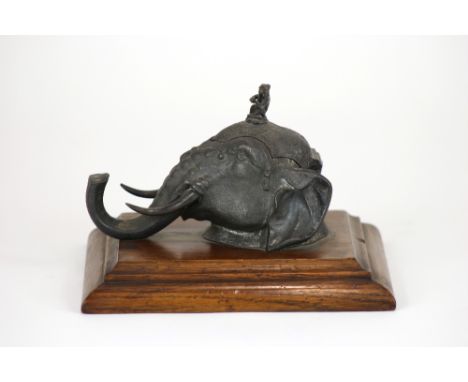 A Victorian cast antimony novelty ink stand, modelled as the head of an Indian elephant, hinged lid with a monkey finial, rec