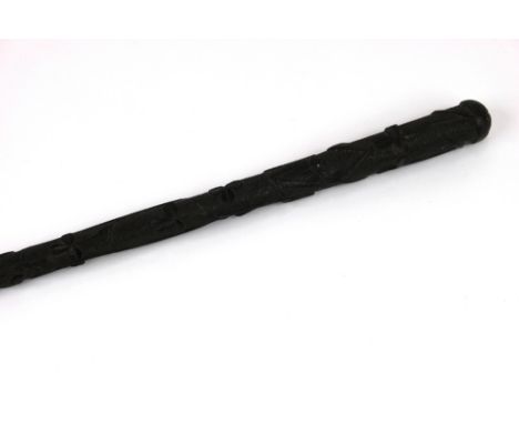 An Irish carved bog oak walking cane, decorated with shamrock, a harp and serpent, 89cm