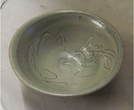 A Jim Malone studio bowl green ash glaze with incised fish decoration, impressed JM mark