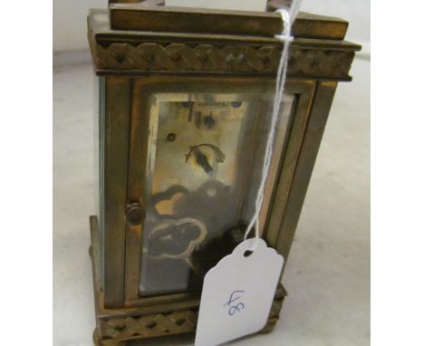 A French brass architectural mantel clock with urn surmount, cream dial movement marked Paris and a pair of matching candelab