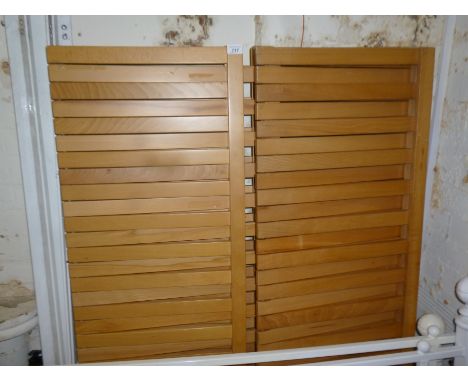 Three modern slatted light wood shelf units.