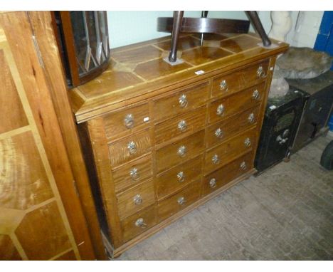 A good quality Flagstone chest of fifteen drawers of varying sizes with applied drop ring handles and star burst back plates,