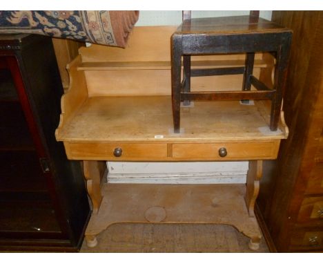 A Victorian stripped pine washstand having a shelf and three quarter gallery back above two frieze drawers and open tier bene