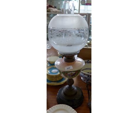 An early 20th Century oil lamp with glass reservoir having floral decoration 