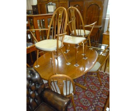 An Ercol medium elm oval pedestal dining table, together with six Ercol medium beech swan back dining chairs, comprising two 