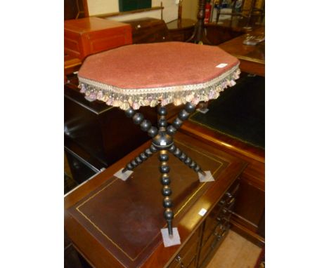 A Victorian Gypsy table, the fabric covered octagonal top raised on a stylish and decorative parcel gilt and ebonised bobbin 