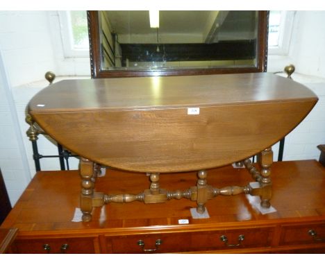 An Ercol medium elm oval drop leaf gateleg coffee table.