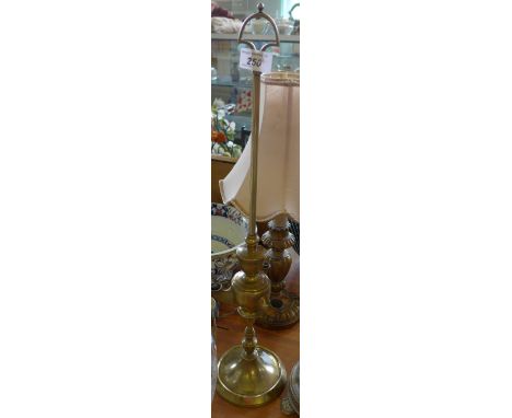 An unusual brass oil lamp circa 1900, raised on a single column with detachable cover enclosing three wicks, height 55cm 