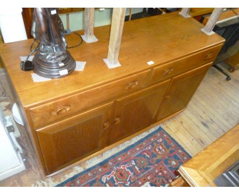 A Ercol medium elm sideboard, the two drawers above three cupboard doors.