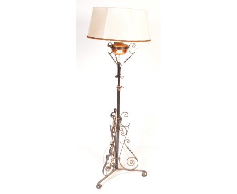 A vintage 20th century ebonised wrought standard lamp / converted oil lamp having a copper reservoir, scrolled detailing sing