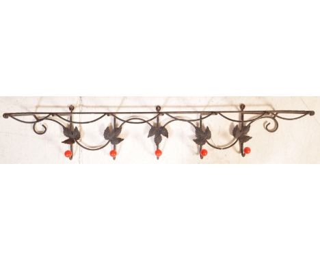 A vintage mid 20th century circa 1950s ebonised metal coat rack having having a set of five hooks with red globular end and a