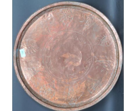 A vintage 20th century Arts &amp; Crafts Newlyn style copper wall plaque tray of circular from having incised decoration to t