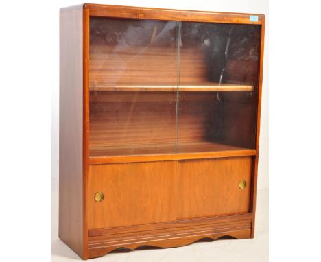 A retro vintage mid 20th century circa. 1960's walnut veneer bookcase. The cabinet having sliding glass twin doors to reveal 