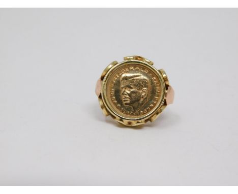 A yellow and pink metal Kennedy commemorative coin ring. 1963, double eagle to the back. Set in a yellow metal pierced settin