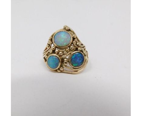 A opal cabochon and yellow metal wire dress ring. Set with three round black opal cabochons set in open back rub over setting