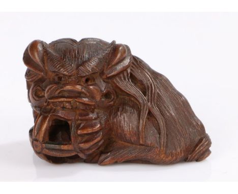 Japanese wood netsuke of Shishi, Asakusa school, signed Masayuki to the base, Shishi holding a pierced puzzle ball with inter