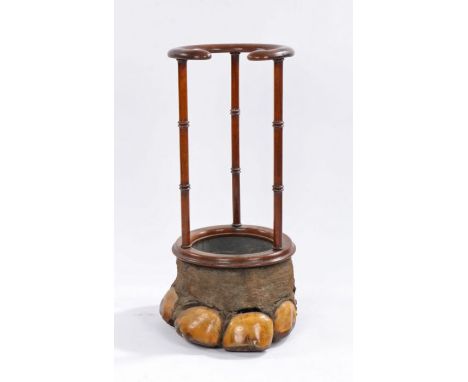 Victorian elephants foot umbrella and stick stand, the mahogany open circular and scroll carved top above triple turned pilas