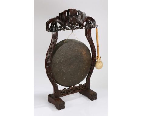 Chinese hardwood dinner gong, the pierced foliate pediment above foliate out-swept supports and central brass gong, on scroll