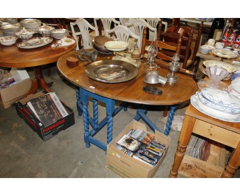 An oak gate leg table raised on barley twist supports