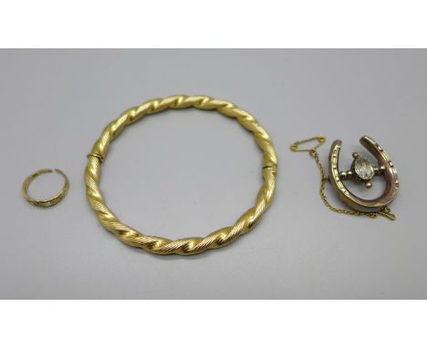 A 9ct gold bangle, 11.2g, a horseshoe brooch marked 'GOLD', 4.1g, and a 9ct gold ring, 0.8g, shank a/f 