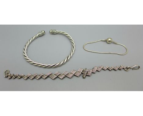 A silver torc bangle, silver Pandora bracelet and one other bracelet 
