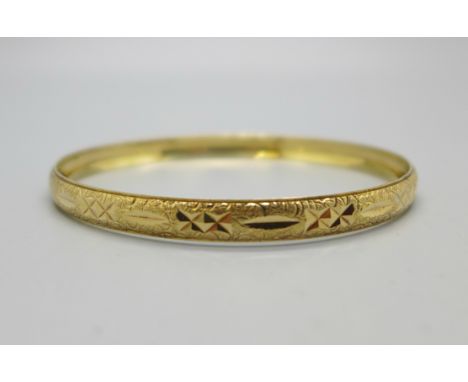 A yellow metal bangle, marked 10K, 7.6g 