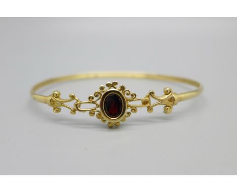 A 9ct gold and garnet set bangle, 4.4g, with case 