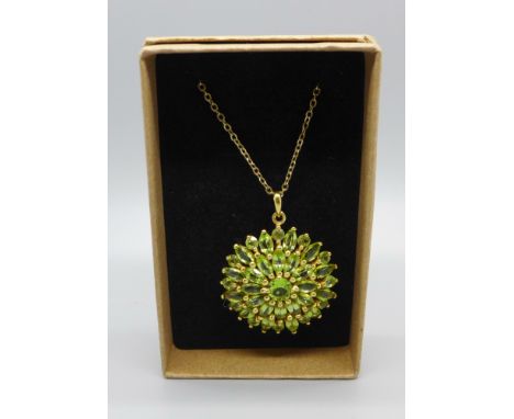 A large silver gilt and peridot pendant and chain 