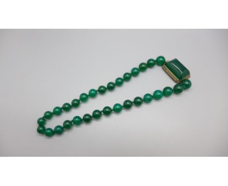 A jade necklace with a large sterling silver set clasp 