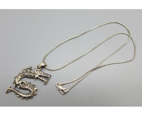 A silver dragon pendant and chain 
