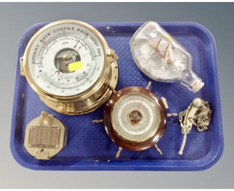 A tray containing nautical themed items including a Schatz brass cased ship's clock, a brass compass, ship's wheel barometer,
