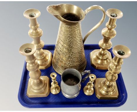 A tray containing three pairs of antique brass candlesticks together with a brass jug and an old English pewter tankard.