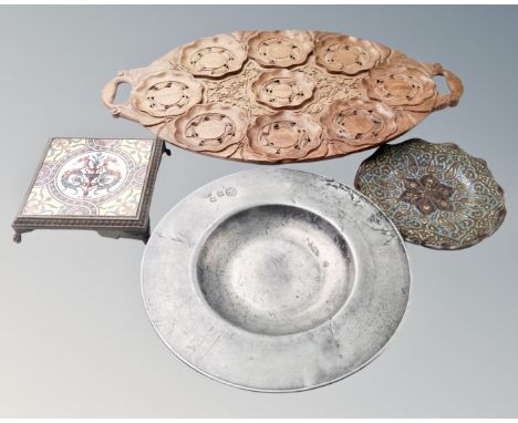 A carved wooden twin handled tray together with an antique pewter plates, a further Eastern brass embossed plate and a tiled 