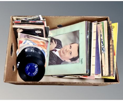 A box containing vinyl records and 7" singles including Western compilations, Iron Maiden, Elvis Presley, Eddie Grant etc.