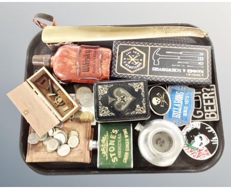 A tray containing English crowns, Mexican coins, hip flask, metal belt buckles, miniature tool sets.