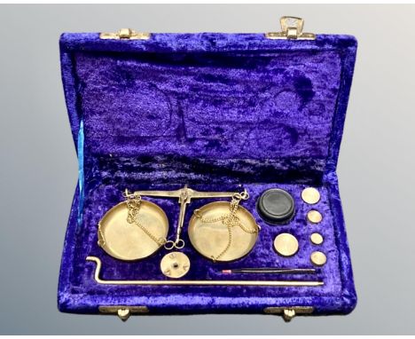 A set of brass portable balance scales in fitted case, with weights and tweezers.